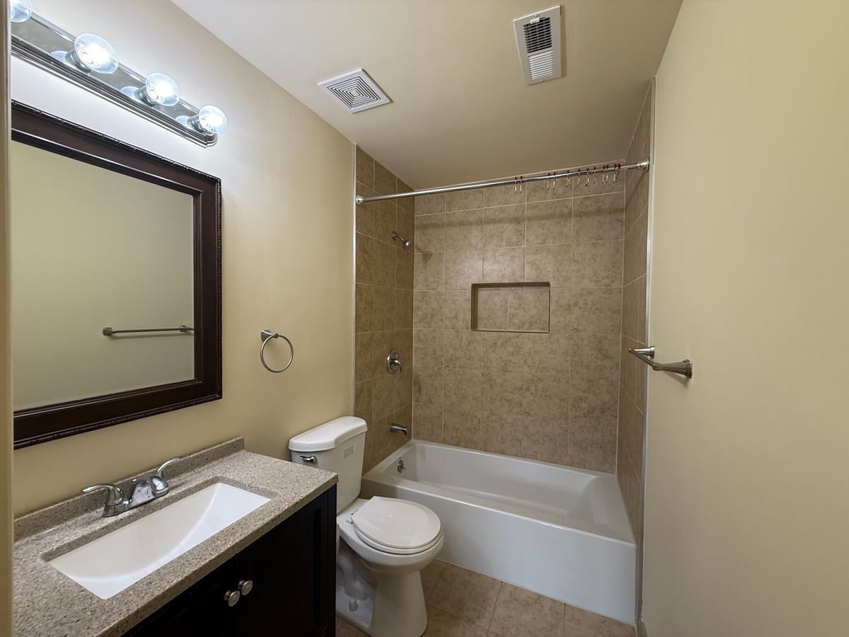 Renovated bathroom with tile surround and vanity