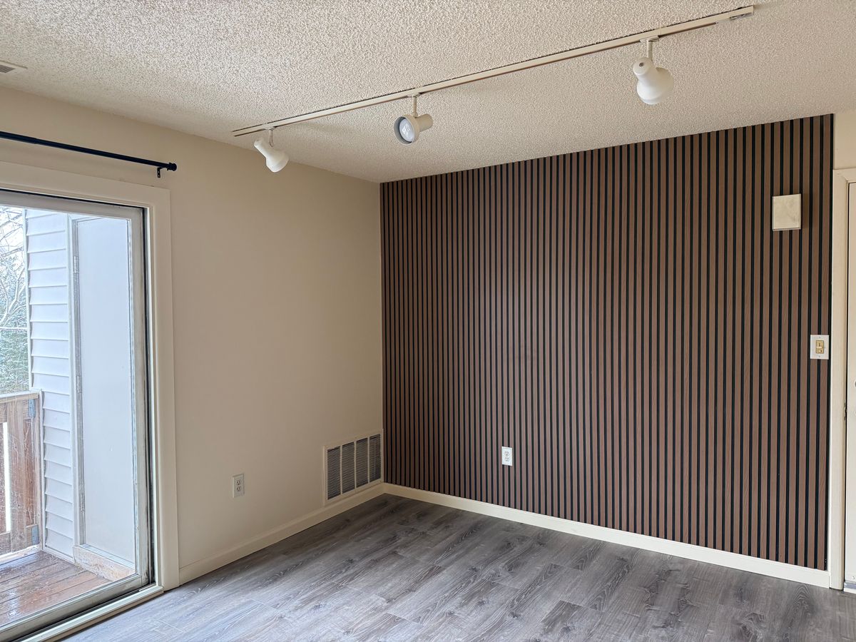 Living room with designer wood slat accent wall and track lighting